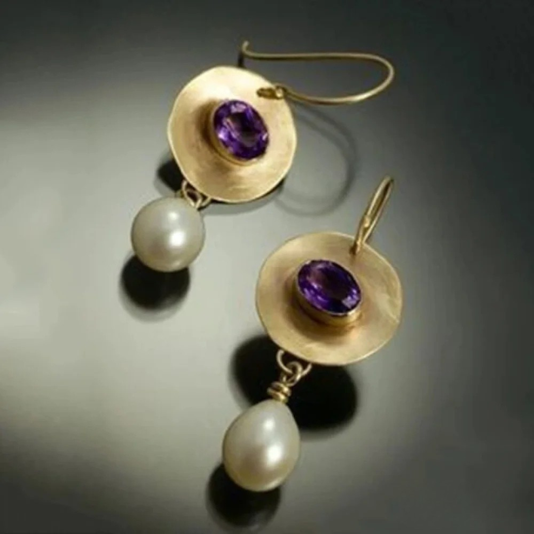 Elegant gold earrings adorned with purple cubic zirconia and a pearl