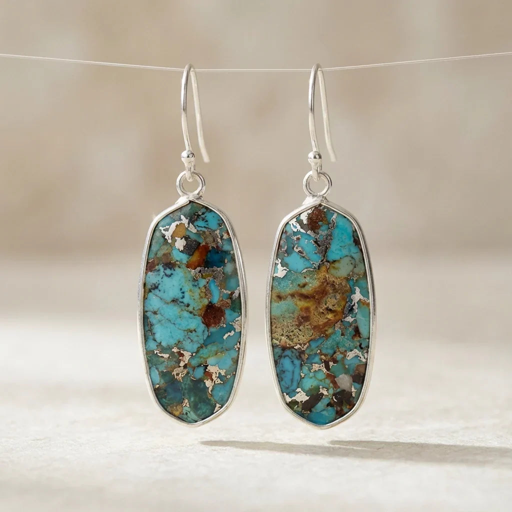 Elongated turquoise-blue and brown mosaic earrings with slim silver-tone borders and hooks.