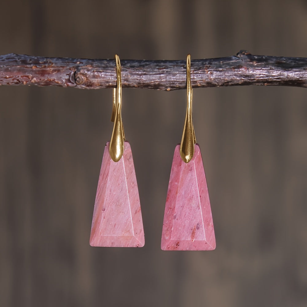 Pink tapered geometric earrings with pale patterning and long gold-tone hooks.