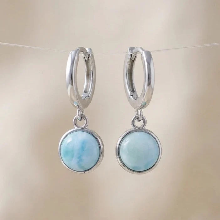 Pale-blue round drops hanging from small silver-tone hoop earrings.