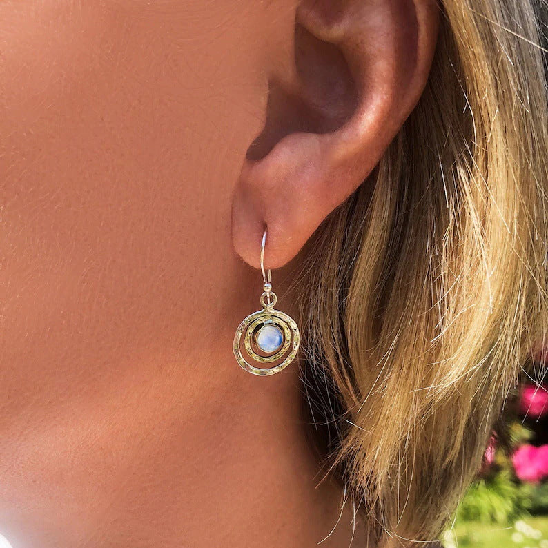 Adeline two-tone round drop earring worn to show the concentric frame