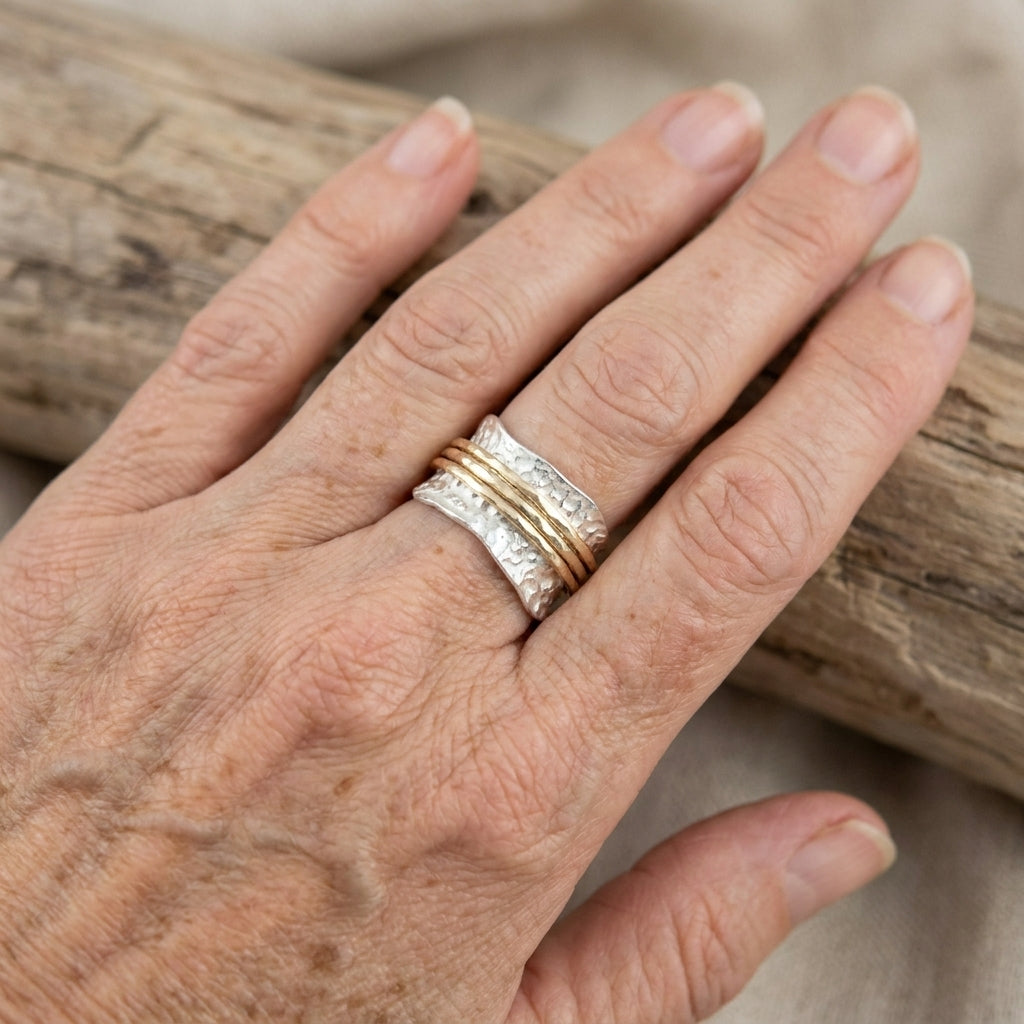 Maeve two-tone wide spinner ring worn on a hand