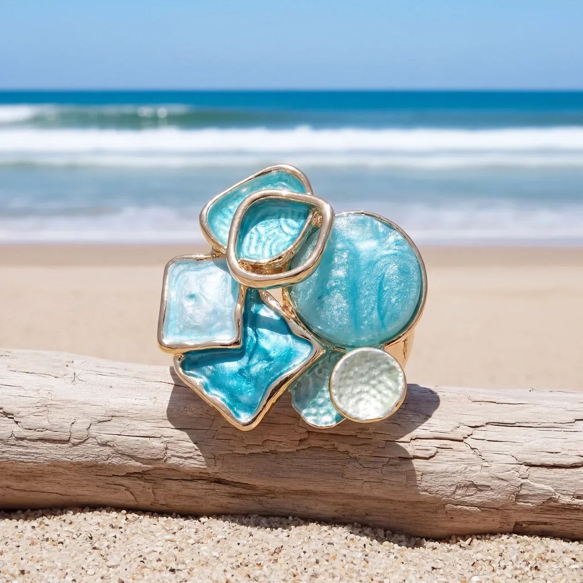 Cluster ring with aqua, turquoise blue, and milky white geometric accents above a broad gold-tone band.