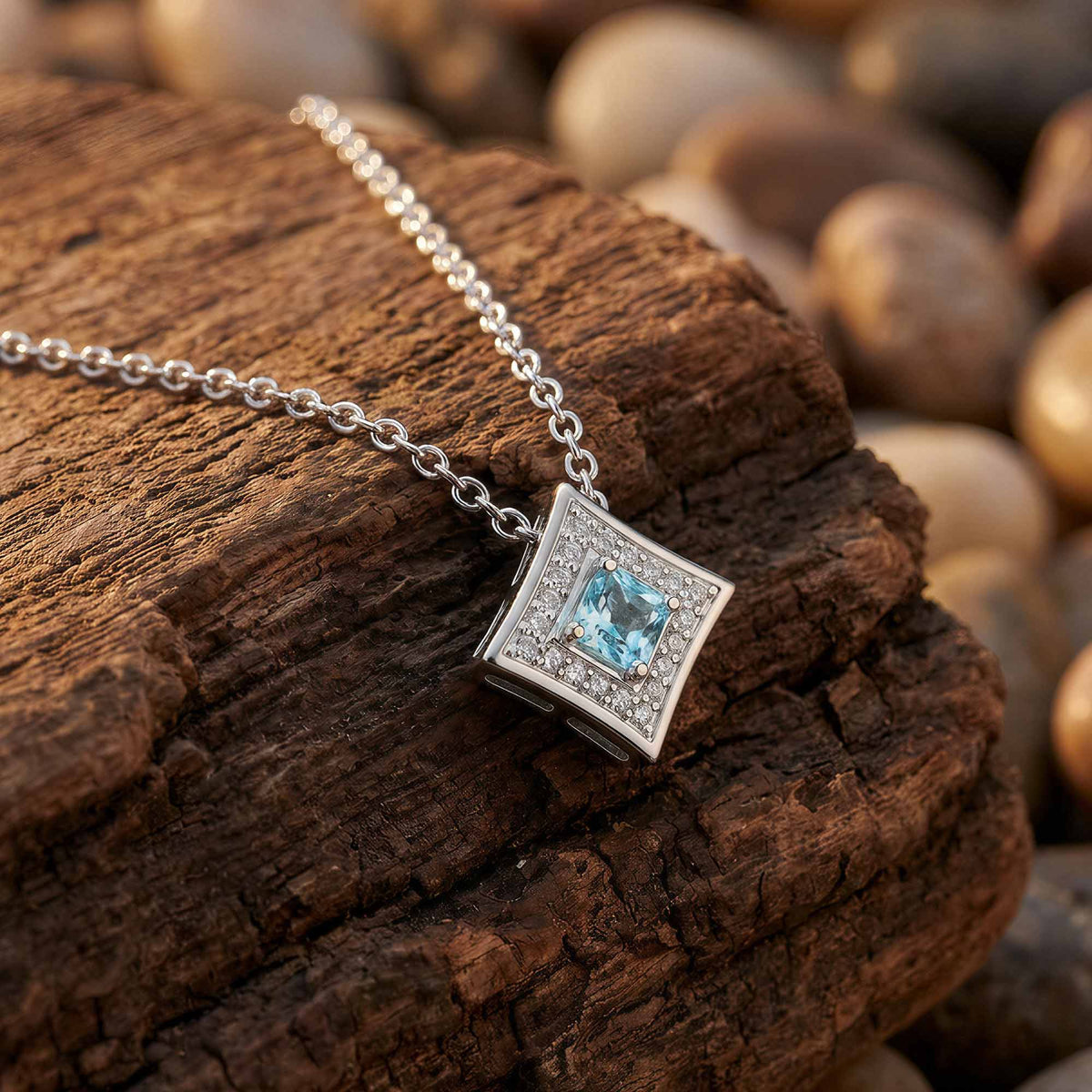 Square icy blue pendant with a frame of clear accents suspended from a silver-tone chain.