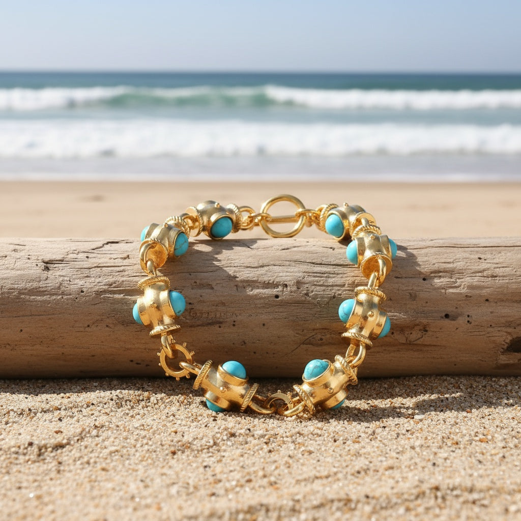Bracelet with rounded turquoise-colored cabochons, decorative gold-tone links, and a ring-and-bar toggle closure.