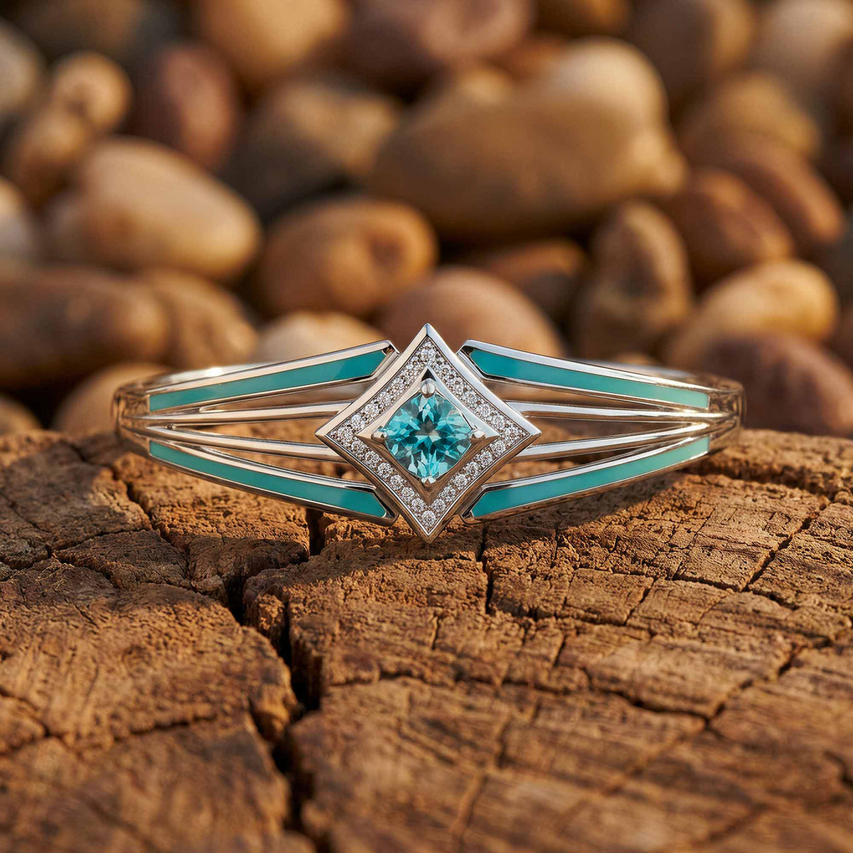Open silver-tone bangle with aqua lines and an icy blue diamond-shaped center outlined by clear accents.