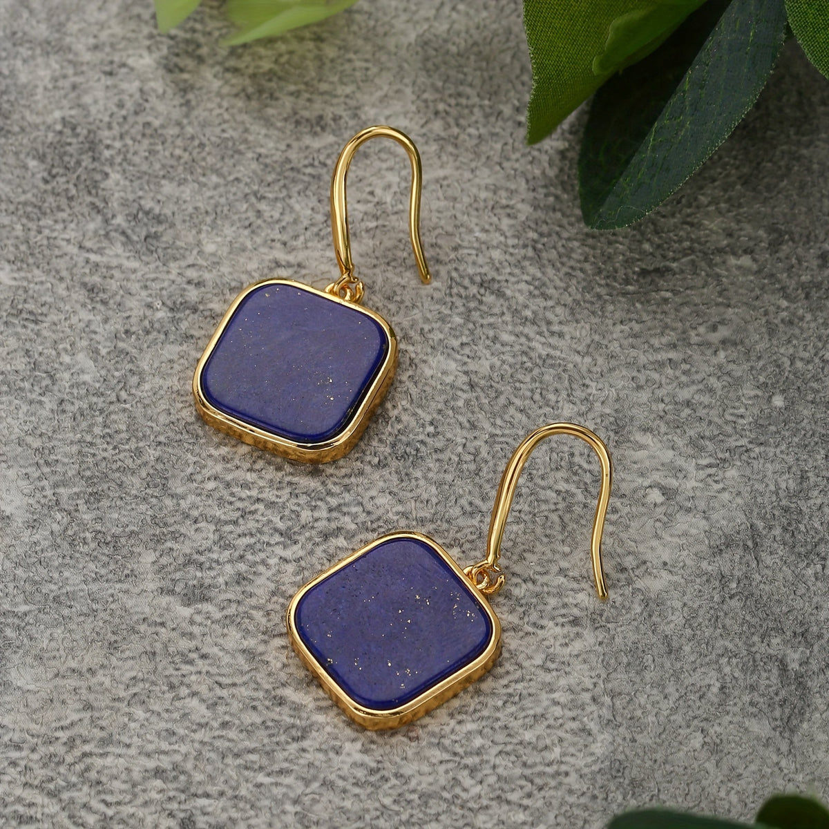 Dark-blue square drop earrings with rounded corners and gold-tone frames and hooks.