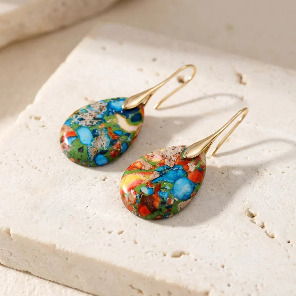 Multicolor mosaic teardrop earrings with blue, green, orange, and red areas and gold-tone hooks.