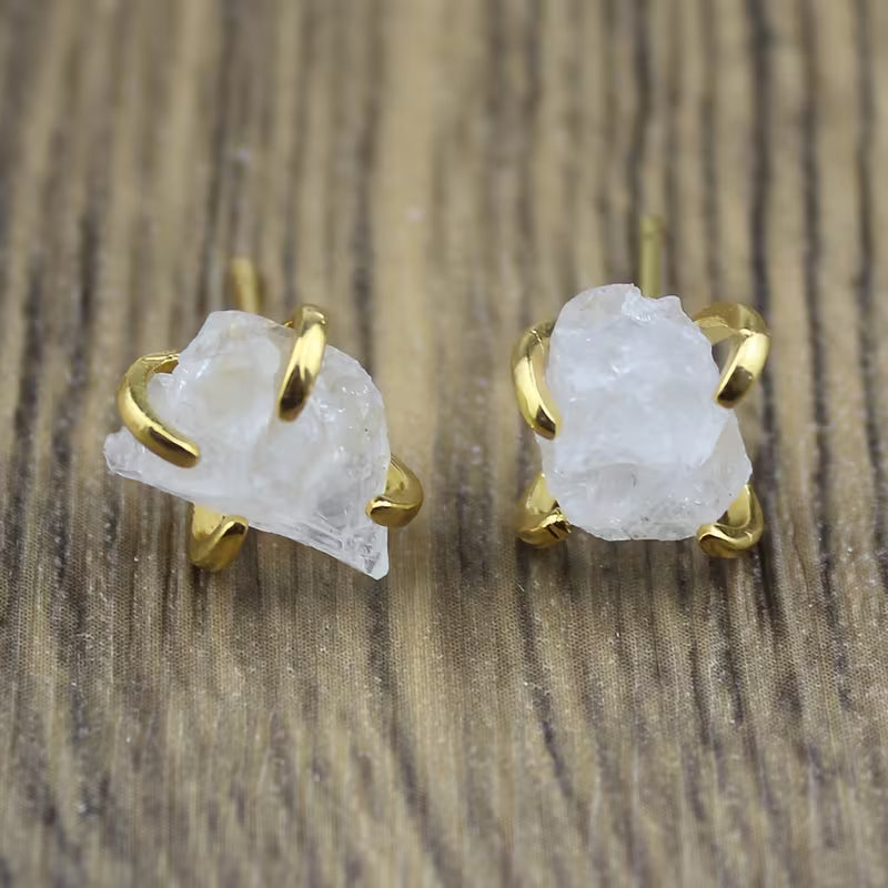 White irregular textured stud earrings held by gold-tone claw settings.