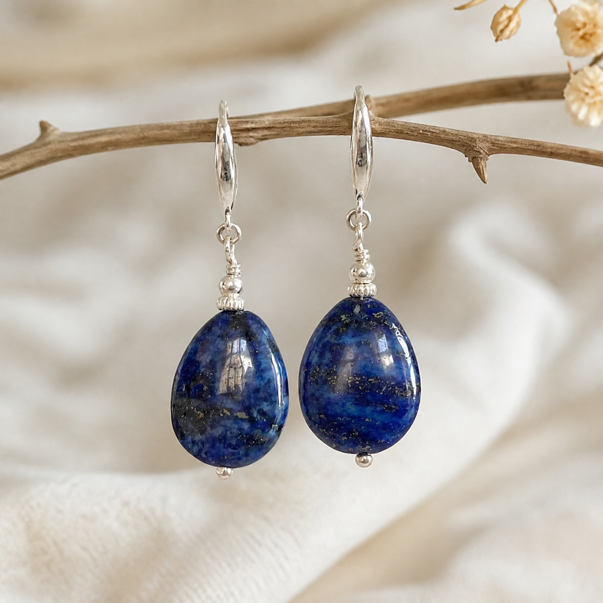 Rounded dark-blue teardrop earrings with silver-tone fittings and small bead accents.
