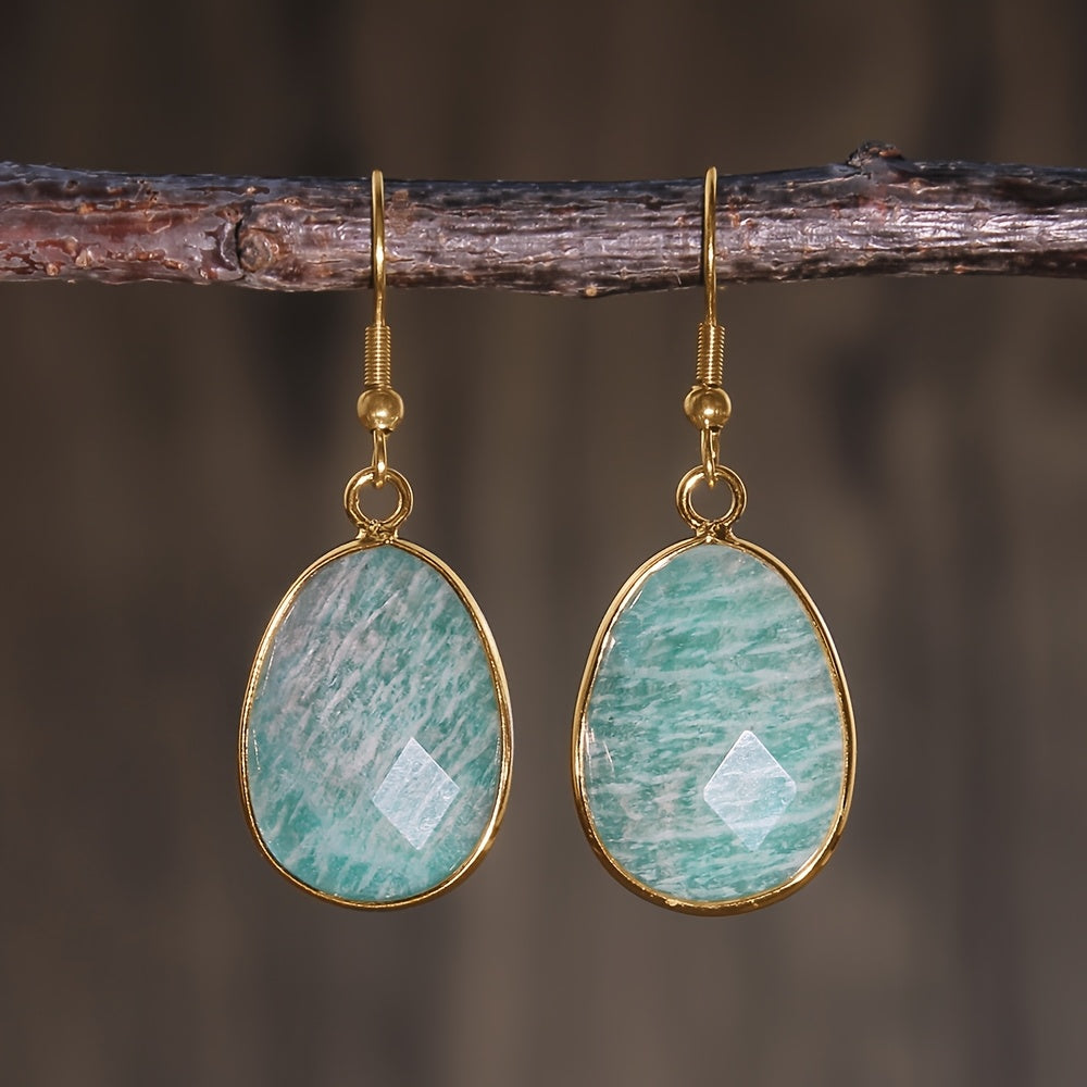 Faceted aqua-blue teardrop earrings with pale patterning, slim gold-tone rims, and hooks.