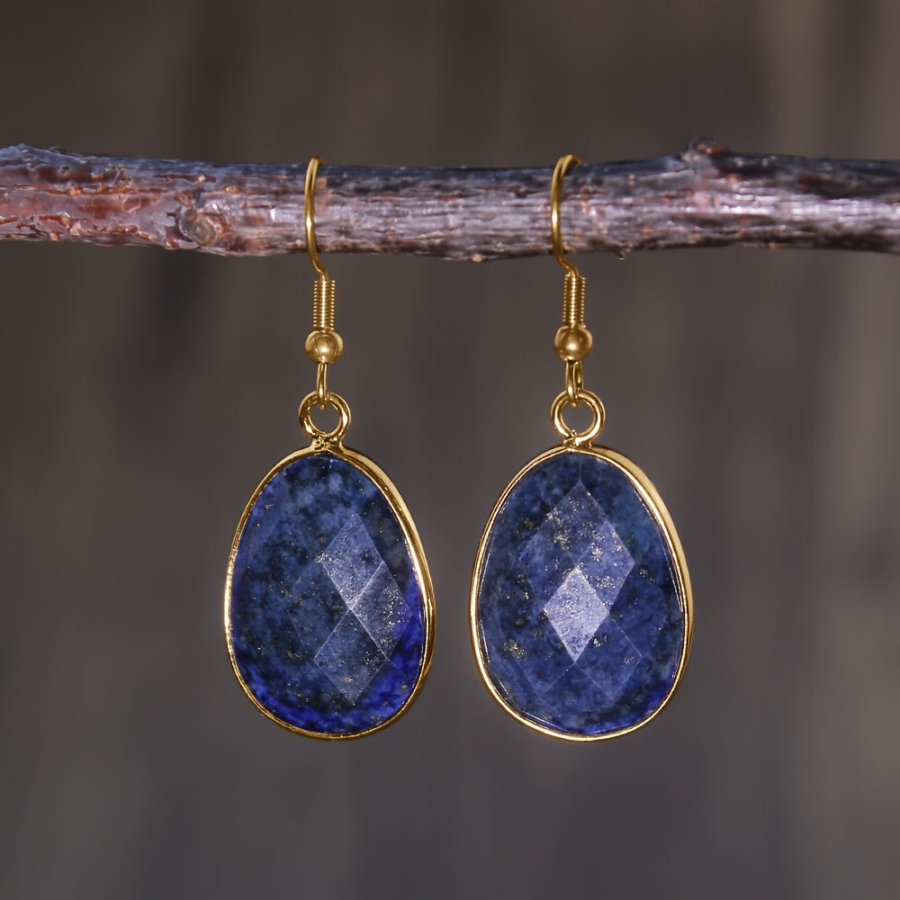 Faceted deep-blue teardrop earrings in slim gold-tone rims with hooks.