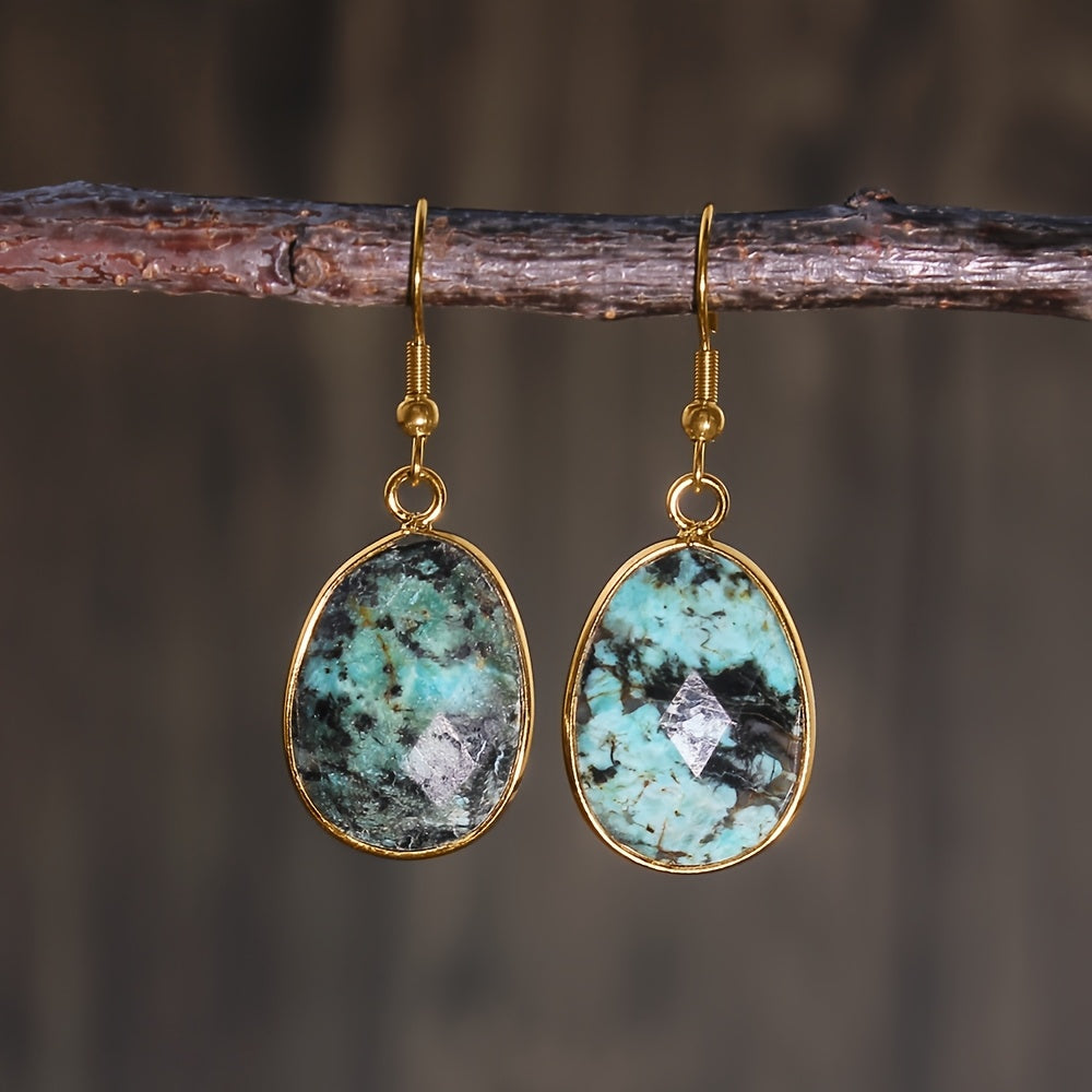 Faceted turquoise-green teardrop earrings with dark mottling, gold-tone rims, and hooks.