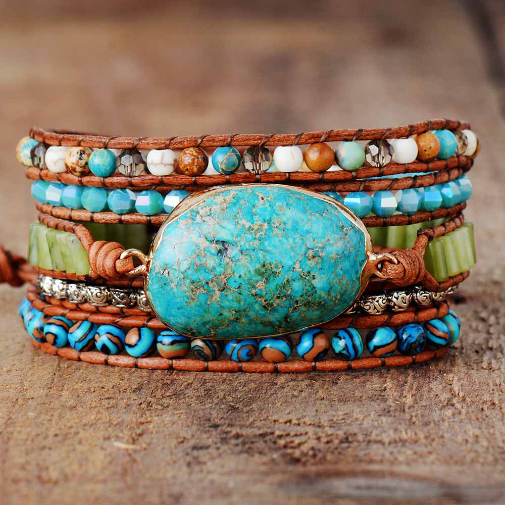 Brown cord wrap bracelet with a turquoise-colored oval center and mixed blue, green, white, and brown beads.