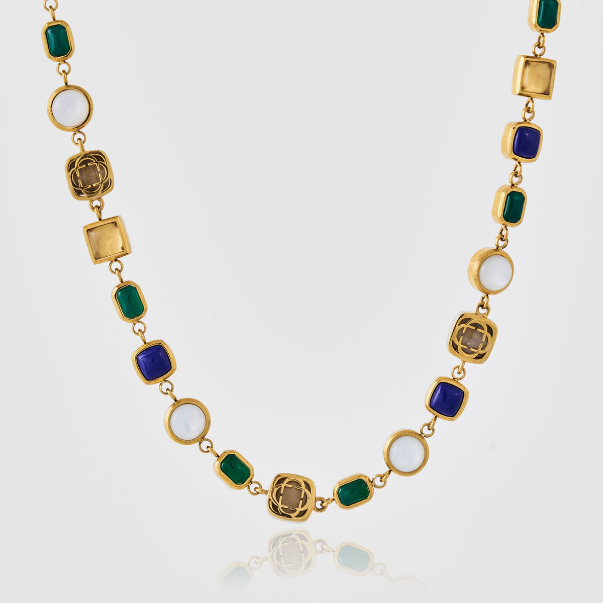Gold-tone link necklace with blue and green rectangular accents, pale circles, and decorative metallic shapes.