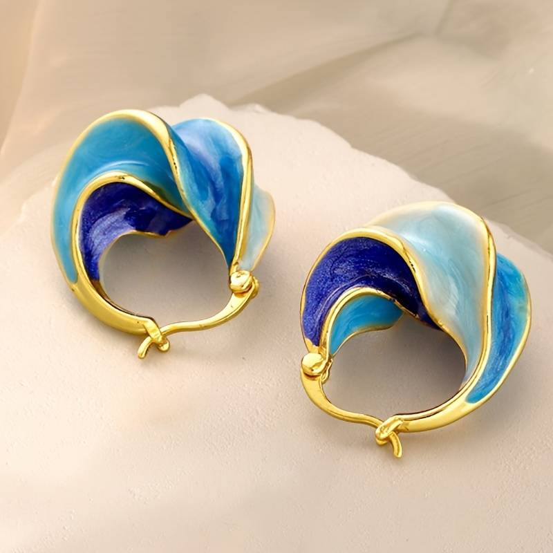 Sculpted hoop-like earrings with light aqua and dark-blue curved sections outlined in gold tone.