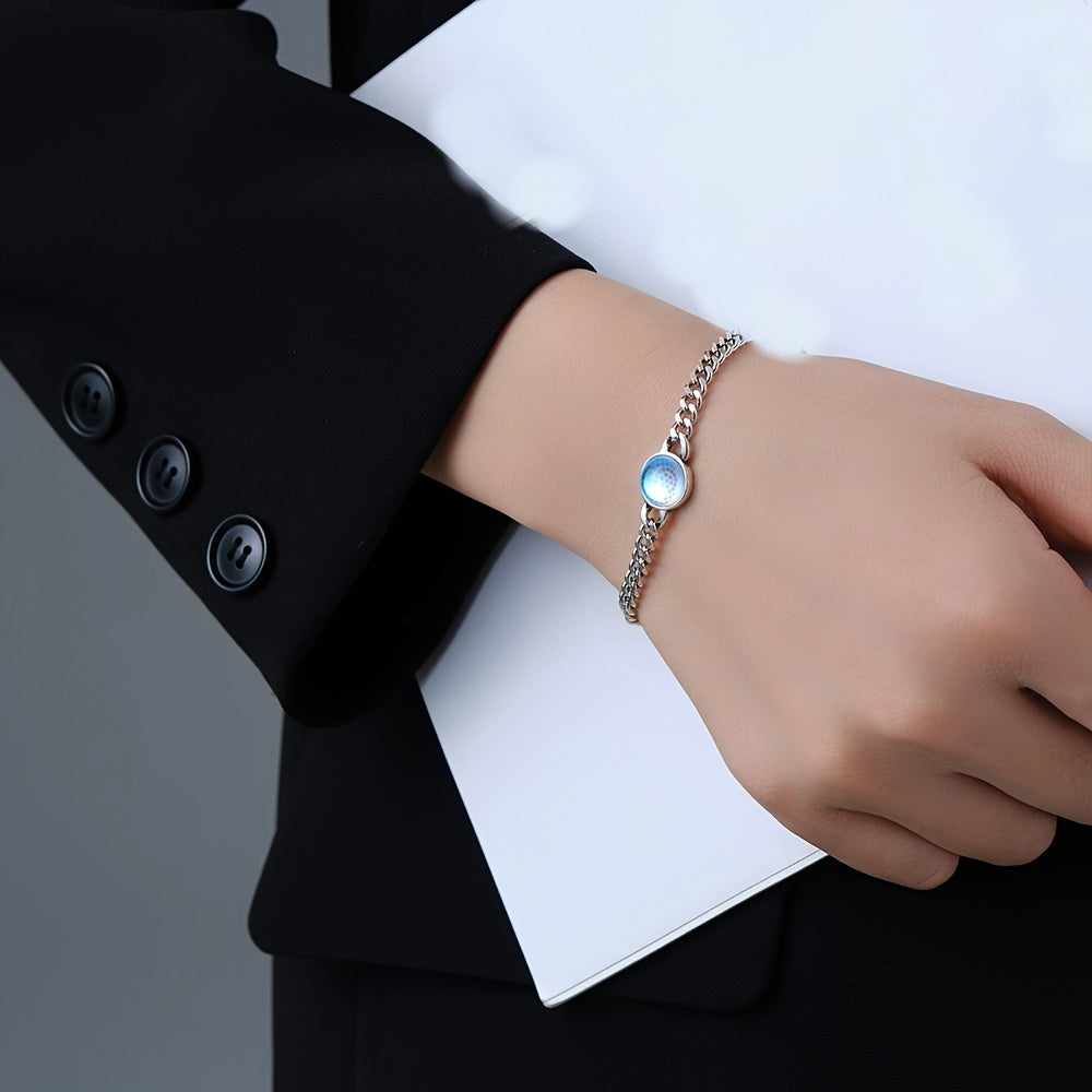 Silver-tone chain bracelet with a pale iridescent center worn on the wrist.