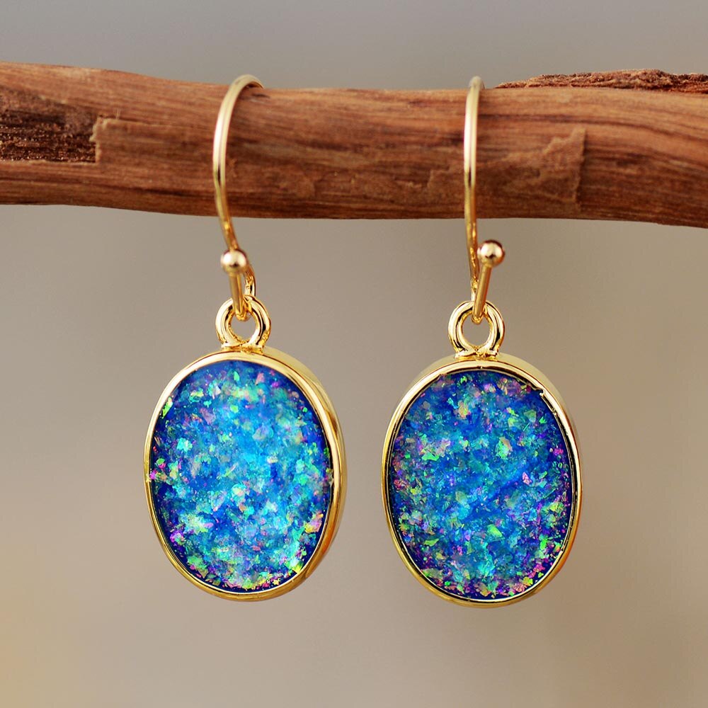 Blue-green iridescent-looking oval drop earrings with slim gold-tone borders and hooks.
