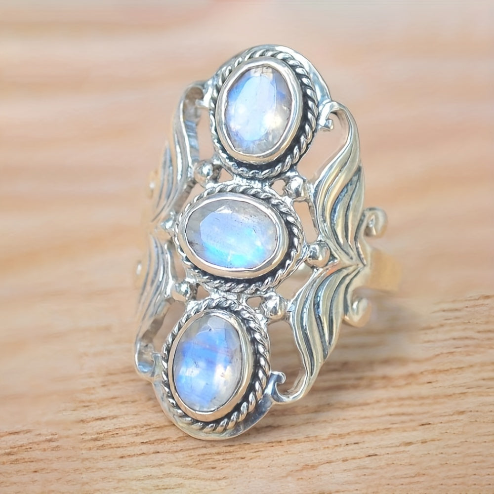Wide silver-tone ring with three pale blue-white oval accents, rope-style borders, and open leaf-like sides.