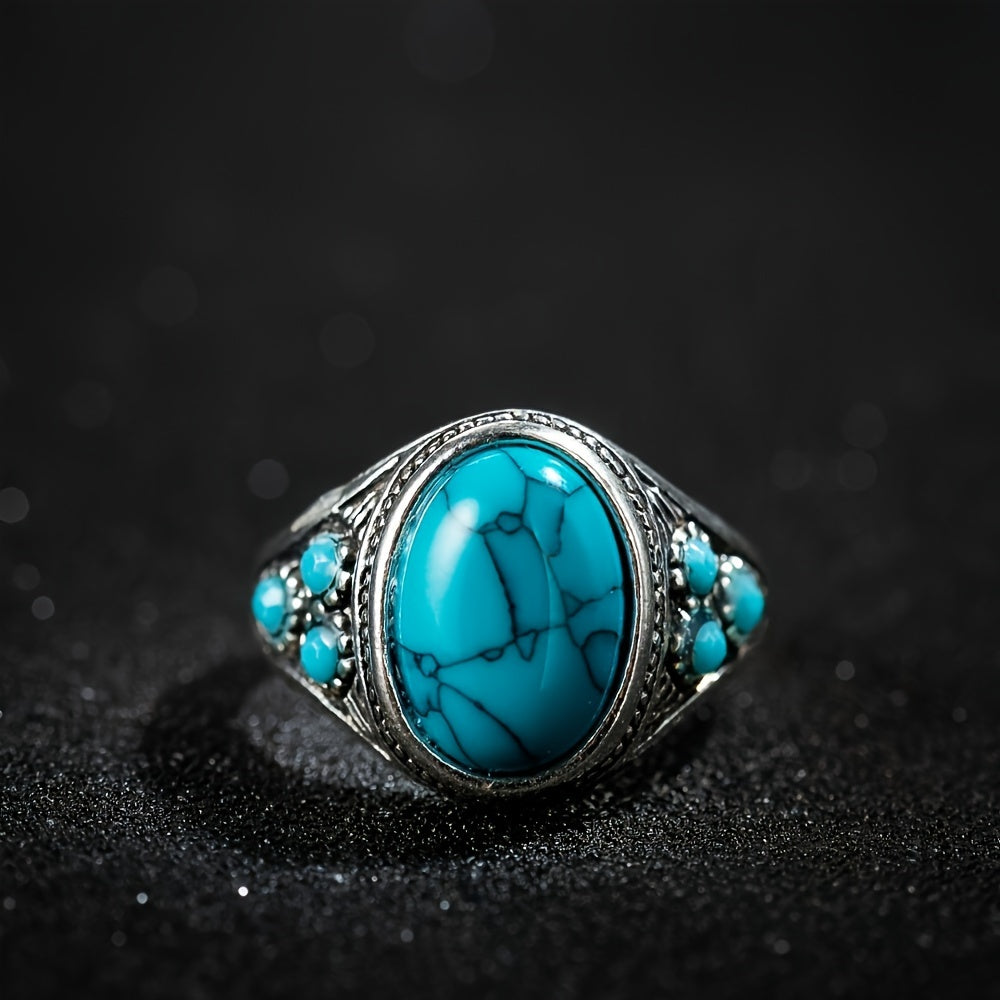 Silver-tone ring with a turquoise-colored oval center, dark veining, and small round blue side accents.